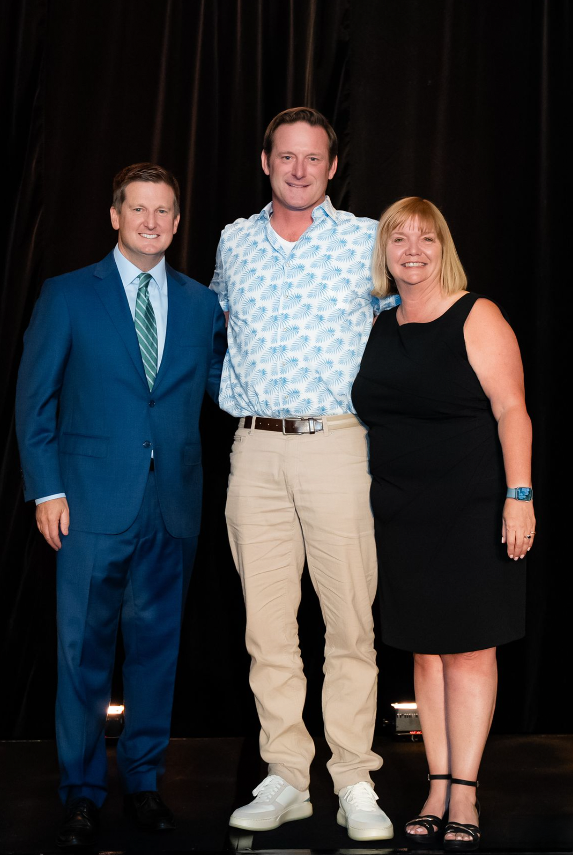 Three guests on stage at an awards evening